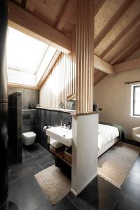 普雷芒翁La Loge de la Dolarde - Chambre Sud的一间带水槽的浴室和一张位于客房内的床