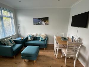 Gorran HavenSunnyVale Valley View Cottage的客厅配有蓝色的沙发和桌子