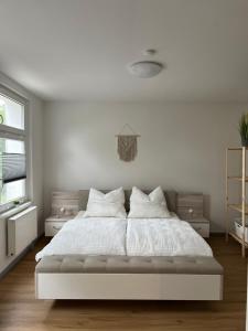 帕塞瓦尔克Gemütliche und moderne Ferienwohnung in der Innenstadt的卧室配有白色的床单和枕头