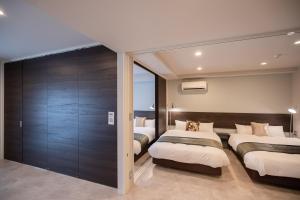 福冈HOTEL so SUMIYOSHI的一间卧室设有两张床和滑动玻璃门