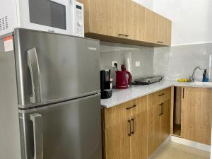 海法Sea Pearl的厨房配有不锈钢冰箱和微波炉。