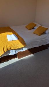 Burton House的卧室配有一张带黄色床单和枕头的大床。