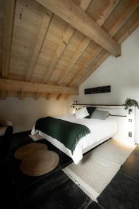 普雷芒翁La Loge de la Dolarde - Chambre Nord-Est的卧室设有白色大床和木制天花板。