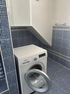 瓦格纳Freundliche Wohnung Nähe Weinstraße für 5 Personen的浴室设有蓝色瓷砖,配有洗衣机。