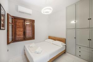 基萨莫斯Villa Katrin的白色的卧室设有床和窗户