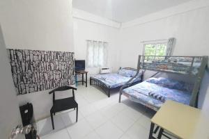 道伊斯Bohol Transient LRUY的客房设有两张双层床和一张书桌。