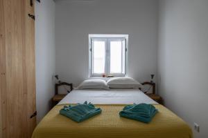 蒙萨拉什Sunrise Monsaraz Green - 1km Castelo Monsaraz com telheiro e jardim的一间卧室配有一张床,上面有两条毛巾