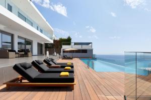 阿齐亚佩拉加Beachfront Villa in Crete - Epavli Luxury Villa的一座带游泳池和黑色沙发的房子