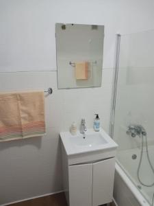 里斯本Simpático apartamento no centro的白色的浴室设有水槽和淋浴。