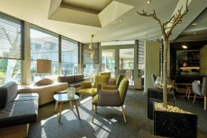 滑铁卢勒克特维赫特酒店的客厅配有许多家具和窗户。