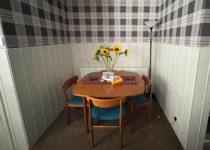 MoulinMoulin Cottage的一张小桌子,上面有向日葵花瓶