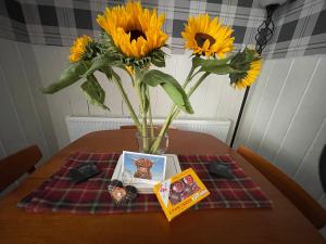 MoulinMoulin Cottage的一个带向日葵的花瓶和一张桌子上的书