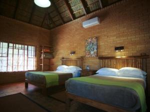 布里茨Mokuru Private Nature Reserve的一间卧室设有两张床和砖墙
