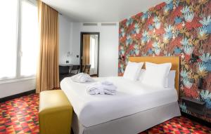 巴黎卡纳尔里贝德尔酒店的卧室配有一张白色大床和花卉壁纸