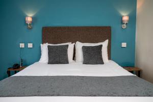 切尔滕纳姆Rising Sun Hotel by Greene King Inns的一间卧室设有一张蓝色墙壁的大床
