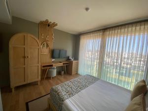 法马古斯塔La Terrazza Hotel的一间卧室配有一张床、一张书桌和一个窗户。