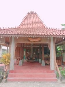 日惹鲁玛优齐旅馆的木制凉亭,在庭院上设有红色屋顶