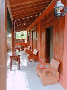 日惹鲁玛优齐旅馆的房屋内带长椅和桌子的门廊