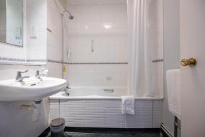 切尔滕纳姆Rising Sun Hotel by Greene King Inns的白色的浴室设有水槽和浴缸。