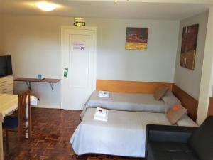 潘普洛纳帕松佩尔纳贝德旅馆的小房间设有两张床和一张书桌