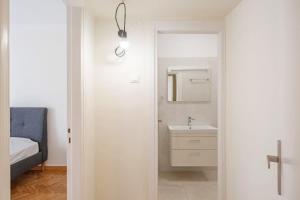 雅典Spacious 3 bedroom apt in Eksarchia的白色的浴室设有水槽和镜子