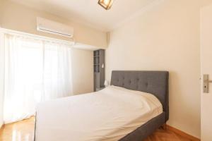 雅典Spacious 3 bedroom apt in Eksarchia的卧室内的一张床铺,设有大窗户