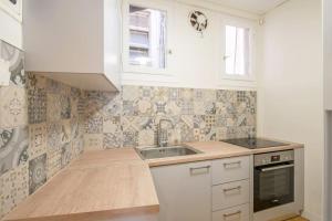 雅典Spacious 3 bedroom apt in Eksarchia的厨房配有白色橱柜和水槽