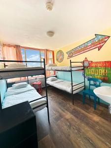 海滨诺德韦克The Flying Pig Beach Hostel, ages 18 - 40的客房设有三张双层床和盥洗盆。