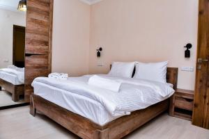 迪利然Maestro Rest House Dilijan的一间卧室配有一张带白色床单的大床