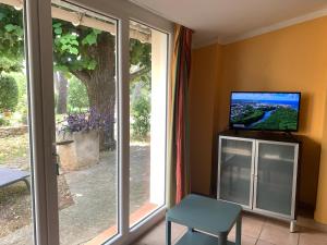 尼姆Mazet proche Golf的一间带电视和滑动玻璃门的客厅