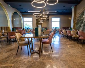 特尔戈维什泰HOTEL NOVA LUXURY的一间带桌椅和吊灯的用餐室