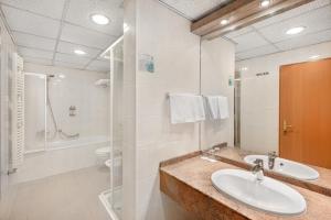 杰尔Danubius Hotel Raba的一间带水槽、淋浴和卫生间的浴室