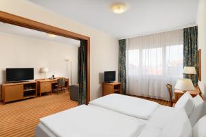杰尔Danubius Hotel Raba的酒店客房配有两张床和一张书桌