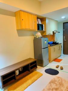碧瑶Cozynest Condotel Baguio的厨房配有不锈钢冰箱和木制橱柜