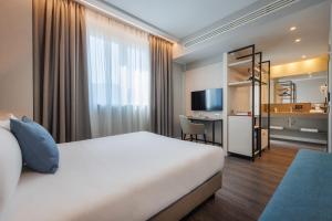 米兰IH Hotels Milano Centrale的配有一张床和一张书桌的酒店客房