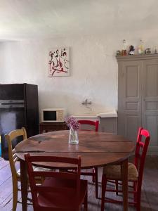 Santa-Lucia-di-MercurioGite casa mea的厨房配有带红色椅子的木桌和桌子四柱床