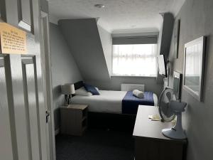 霍利Corner House Hotel Gatwick with Holiday parking的一间小卧室,配有床和窗户