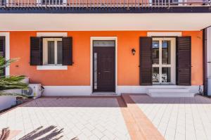 弗洛里迪亚Casa Lilium a Floridia的橙色的房子,有黑色百叶窗和门