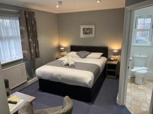 霍利Corner House Hotel Gatwick with bookable Holiday parking的一间卧室,床上有两双鞋