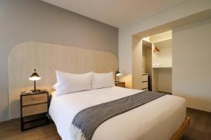 利马La Mar Miraflores by Wynwood House的卧室配有白色的床和木制床头板