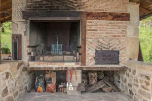 Murueta-Orozkocaserio vasco con piscina y barbacoa的石头壁炉,内有炉灶