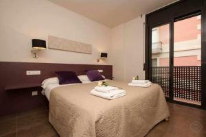 巴塞罗那Port VII Apt centrico acogedor w balcon 23的一间卧室配有两张带毛巾的床
