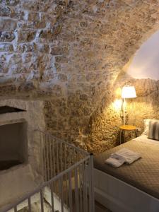 奥斯图尼Cà Giò的卧室配有一张石墙床