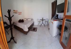 马里卡Suite Privativa Lar e Aconhego的小房间设有一张床和一台冰箱