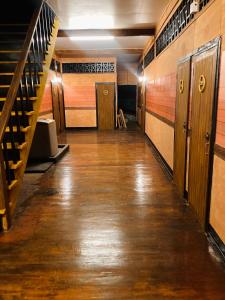 梭桃邑โรงแรมคุ้มเดช - KoomDech Hotel的空的走廊铺有木地板,设有楼梯