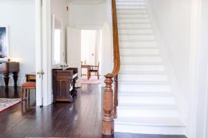 滨湖尼亚加拉Woodbourne Inn的房屋内的楼梯,拥有白色的墙壁和木地板