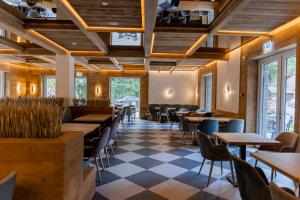 博尔沙Hotel INA的餐厅设有木制天花板和桌椅