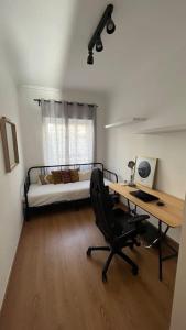 里斯本Charming apartment in Lisbon的一间卧室配有一张桌子和一张带书桌的床。