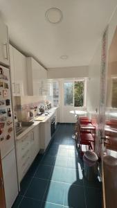 里斯本Charming apartment in Lisbon的厨房配有白色橱柜和蓝色瓷砖地板。