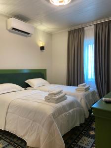 Këlcyrë“Sarajet” Bed&Breakfast的两张位于酒店客房的床,配有毛巾